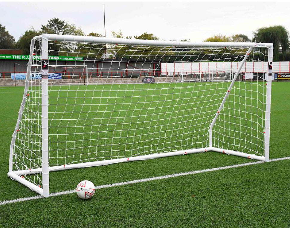 Precision 16x7 PVC Composite Goal on a grass field with soccer ball nearby, featuring a durable net and strong frame.