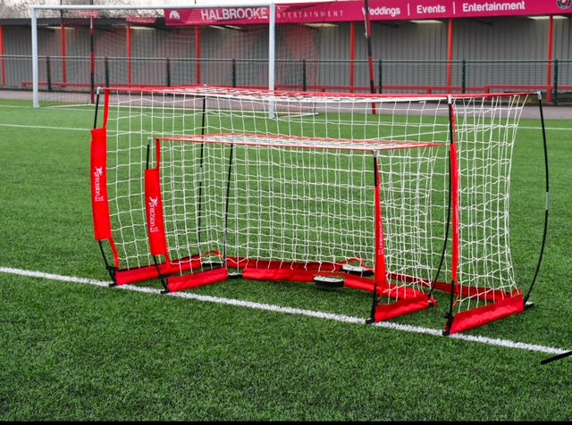 Versatile Precision Flexi Net Goal set up on a sports field with red accents, designed for quick assembly and durability.